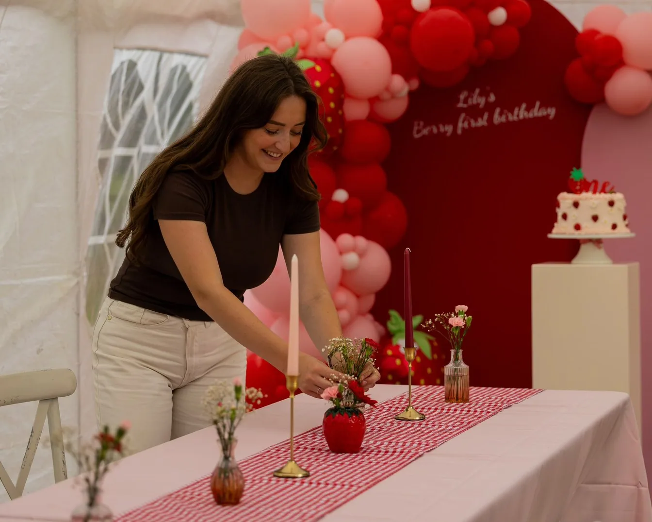 Dionne zet bloemen en kaarsen recht op een gedekte feesttafel